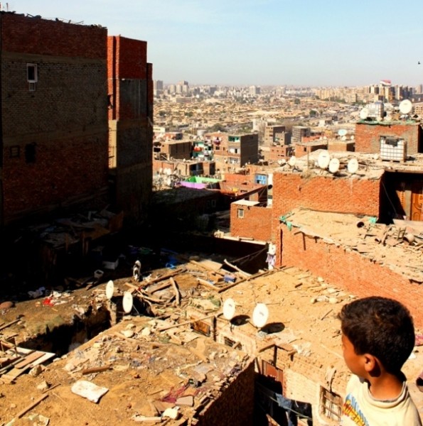 Child on rooftop looking out over Cairo